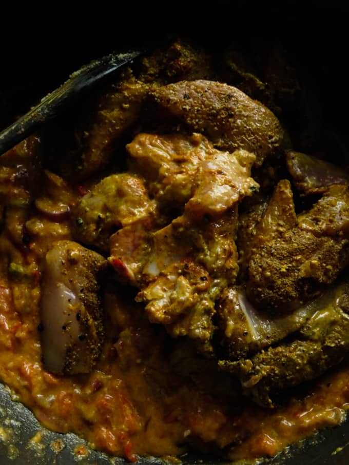 adding the chicken parts to the almond curry sauce.