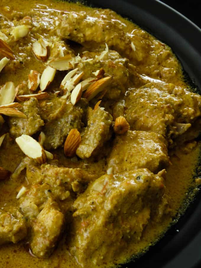 badam chicken or almond chicken curry in a bowl with almond slices on top.