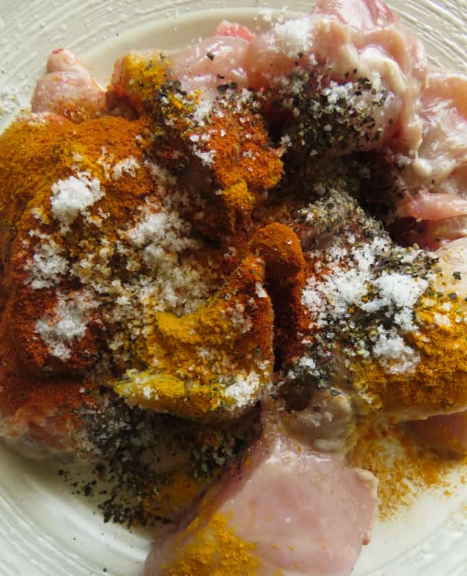 chicken pieces in a plate ready to be marinated with Indian spices.