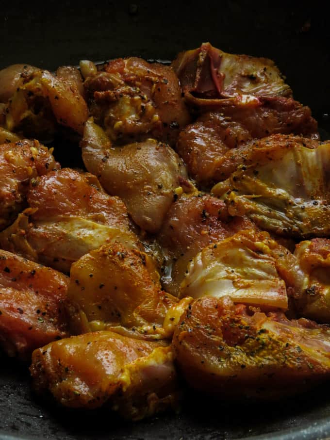 pan frying the marinated chicken parts in a wok to make the Indian chicken roast.