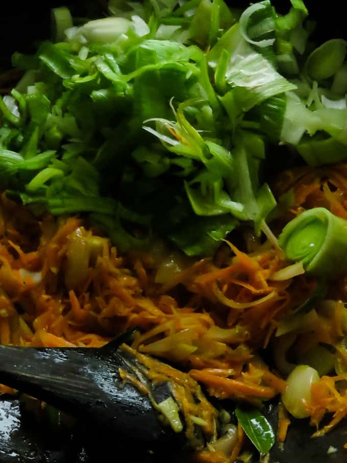 cooking leeks and carrots to make the mixed vegetable noodle.