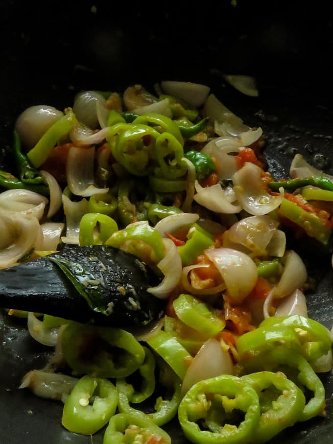 softening the capsicums, onions, green chillies to make the dolphin kottu.