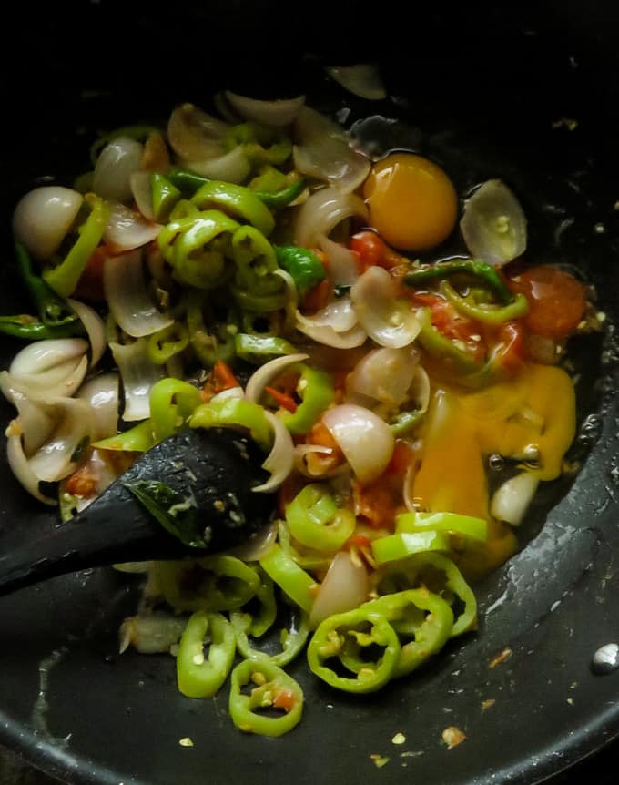 adding eggs to the capsicum, onion mixture in the pan.