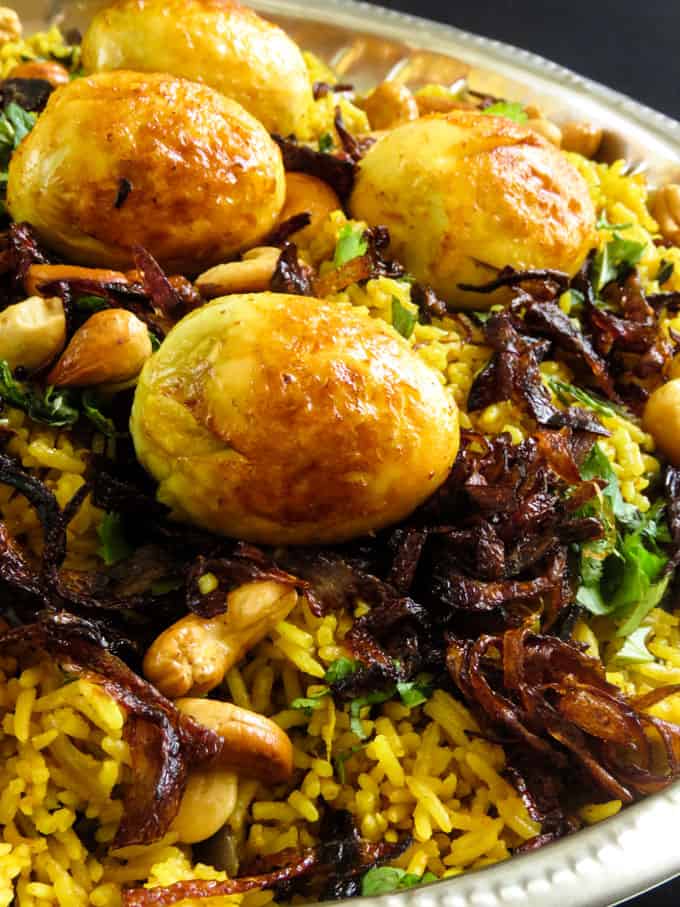 fried eggs, cashews and caremelized onions garnished over an egg biryani.