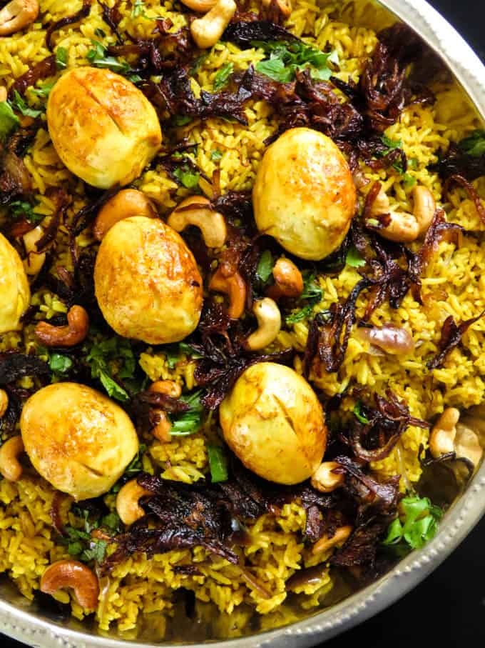 large platter of egg biryani served with fried eggs.