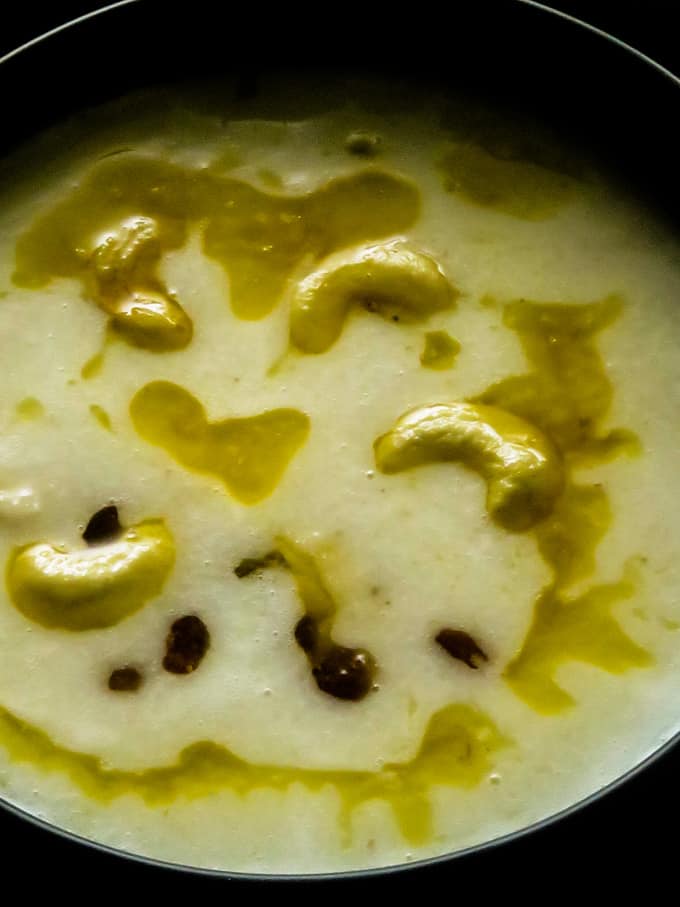 sweet semolina porridge in a bowl with ghee, cashews and raisins.