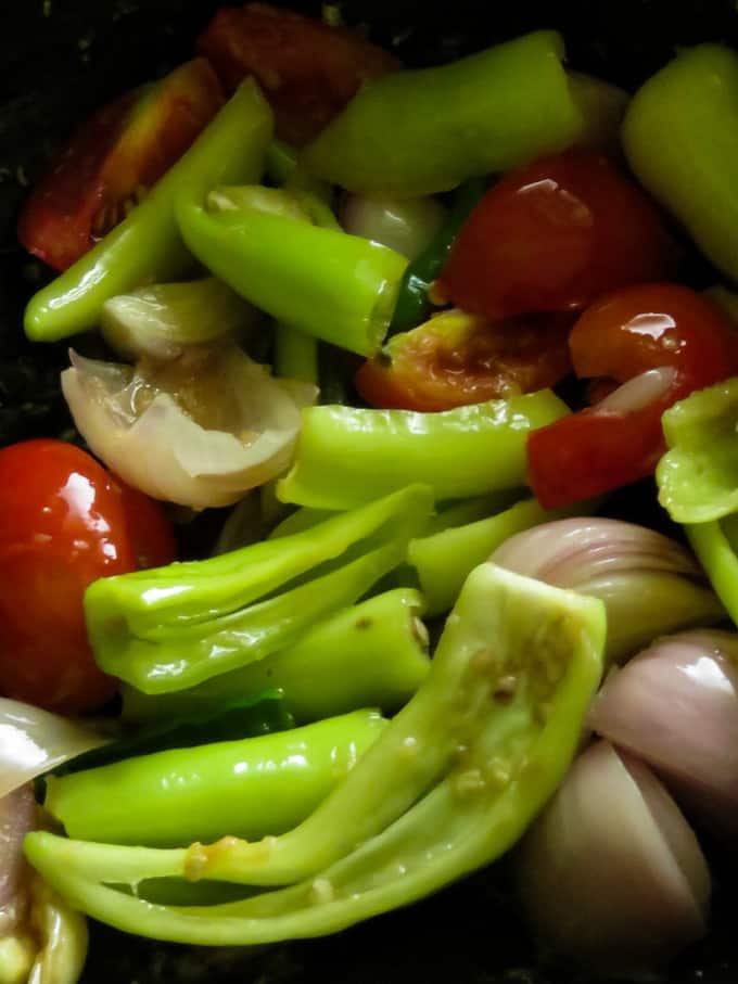 stir-frying the green peppers, onions and tomatoes to make the deviled fish.