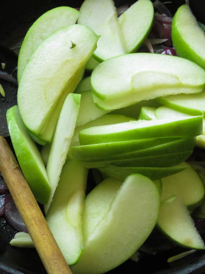 slices of apples stir-fried with onions and turmeric powder to make the apple stir-fry.