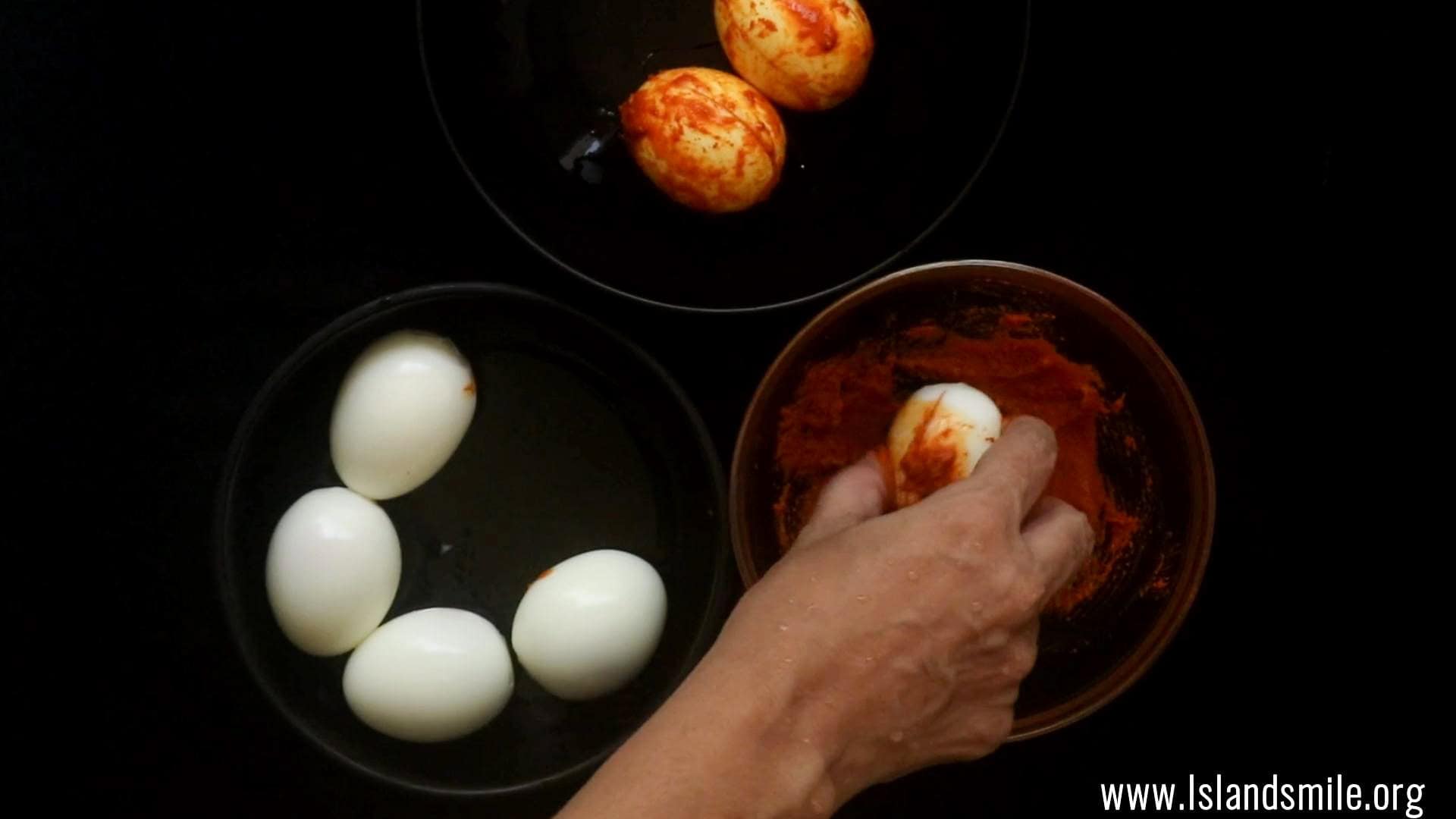 roll the eggs on a masala paste to fry them and cook the egg biryani.