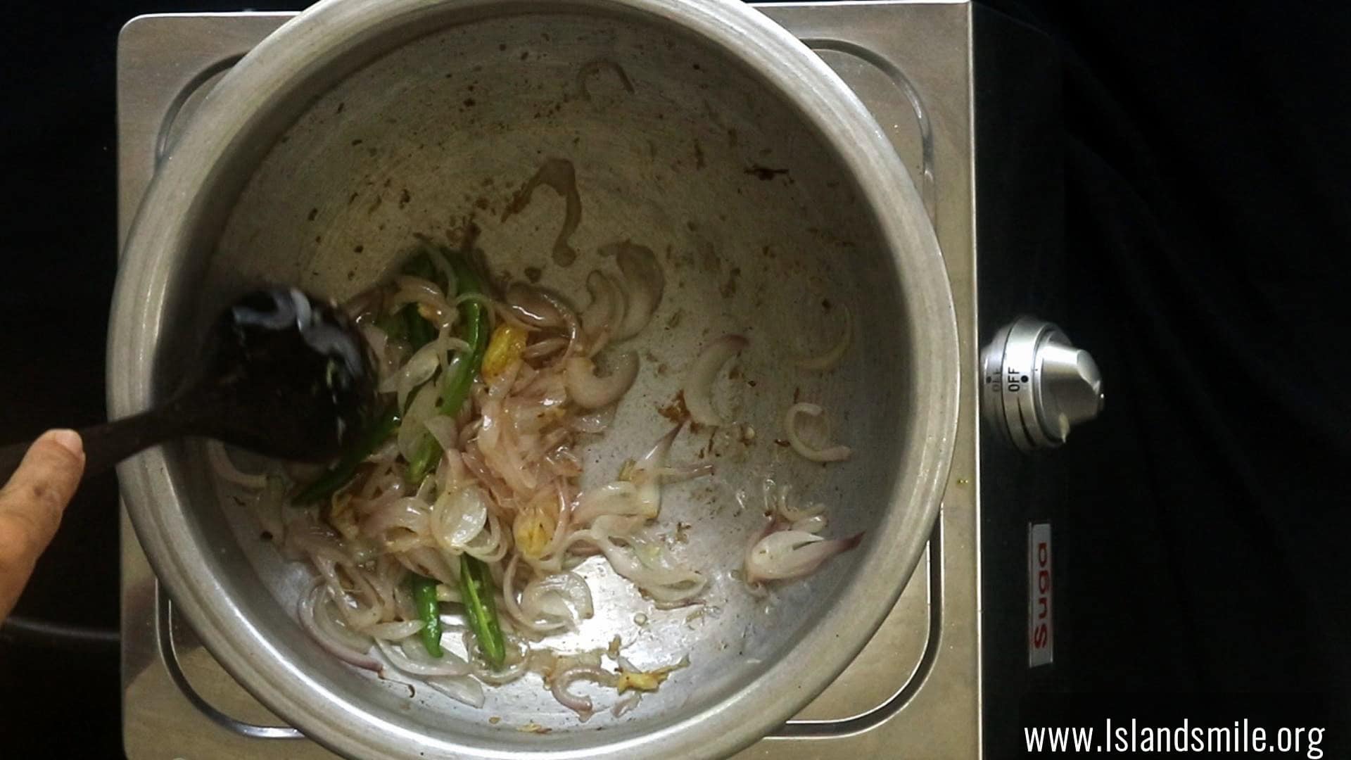 cooking the onions, green chillies and ginger garlic to make the spice paste for the egg biryani.