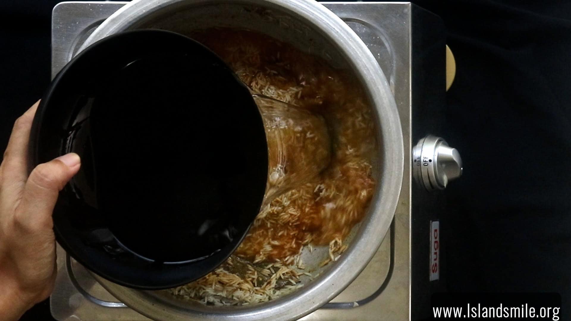 adding water to cook the egg biryani.