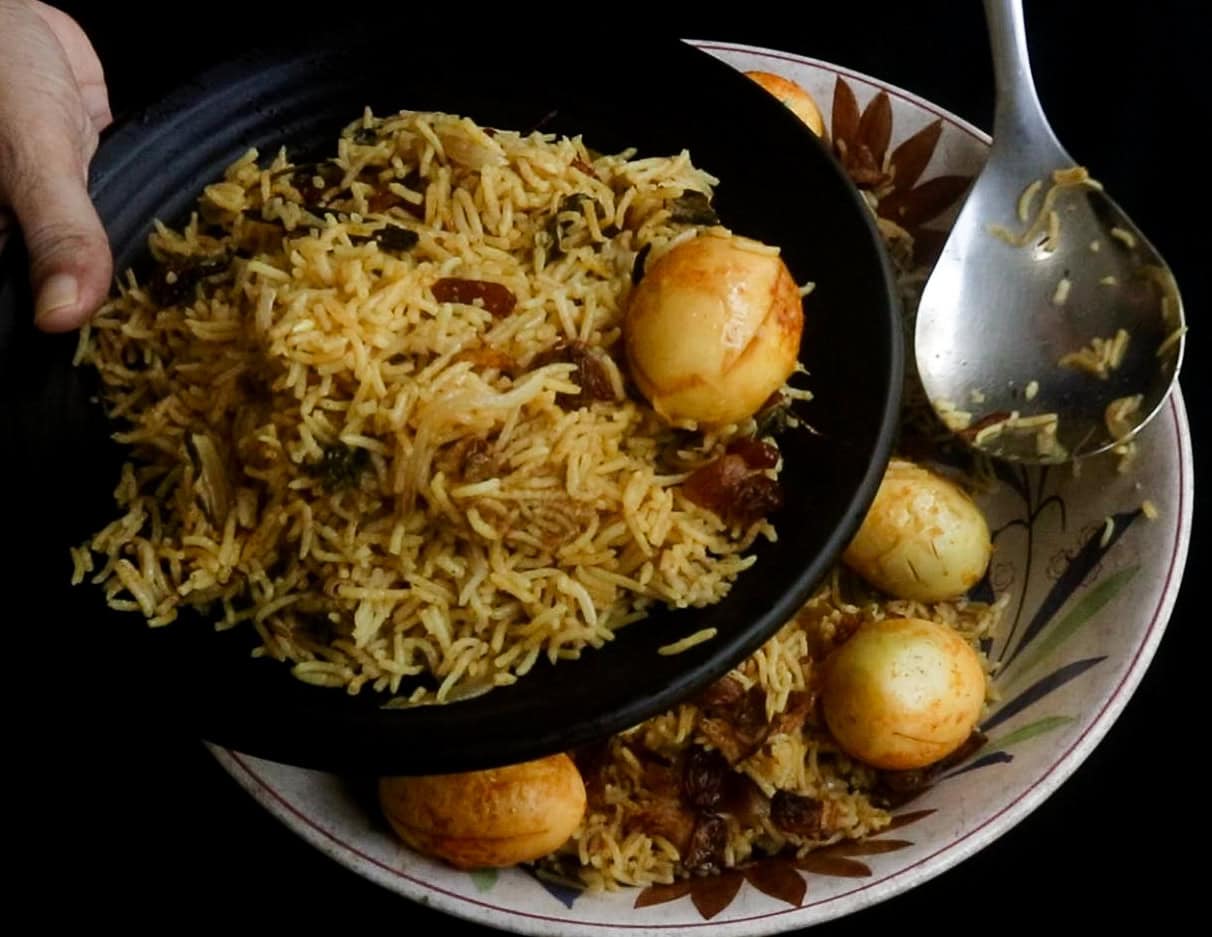 Serving the egg biryani on a black platter