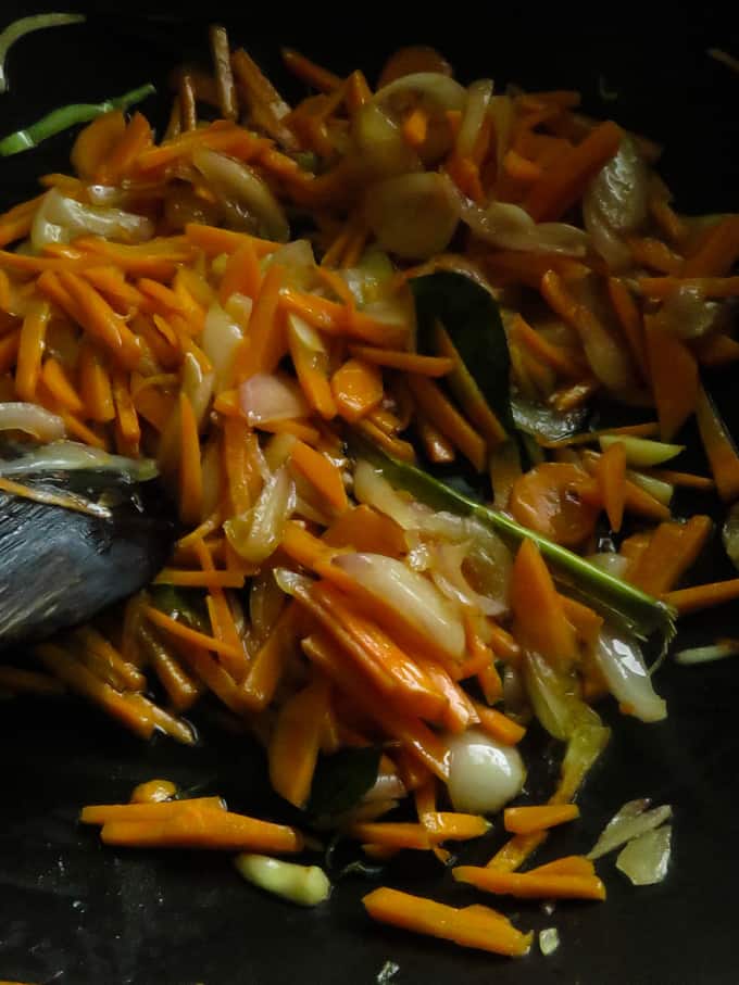 adding the chopped carrots to the onions and garlic.