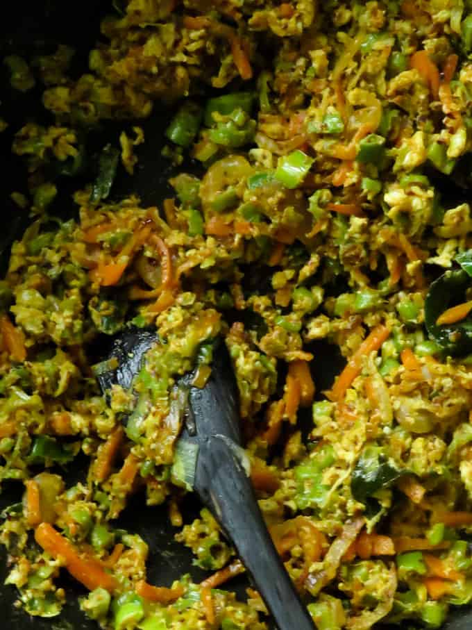 mixing the chillie paste, rice and the vegetables to make the fried rice.