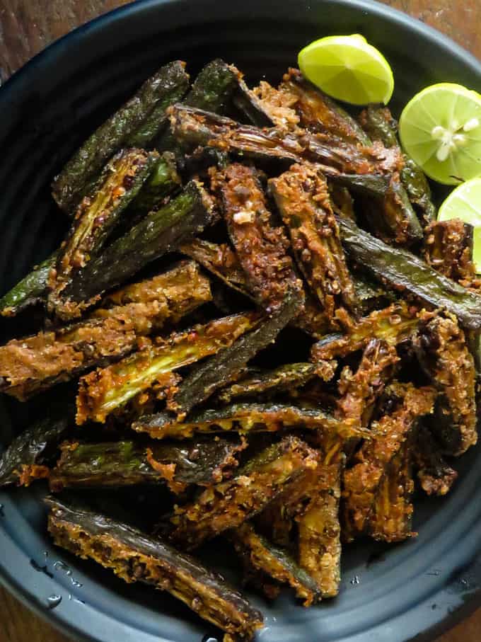 ladies fingers fry with wedges of lime on a plate