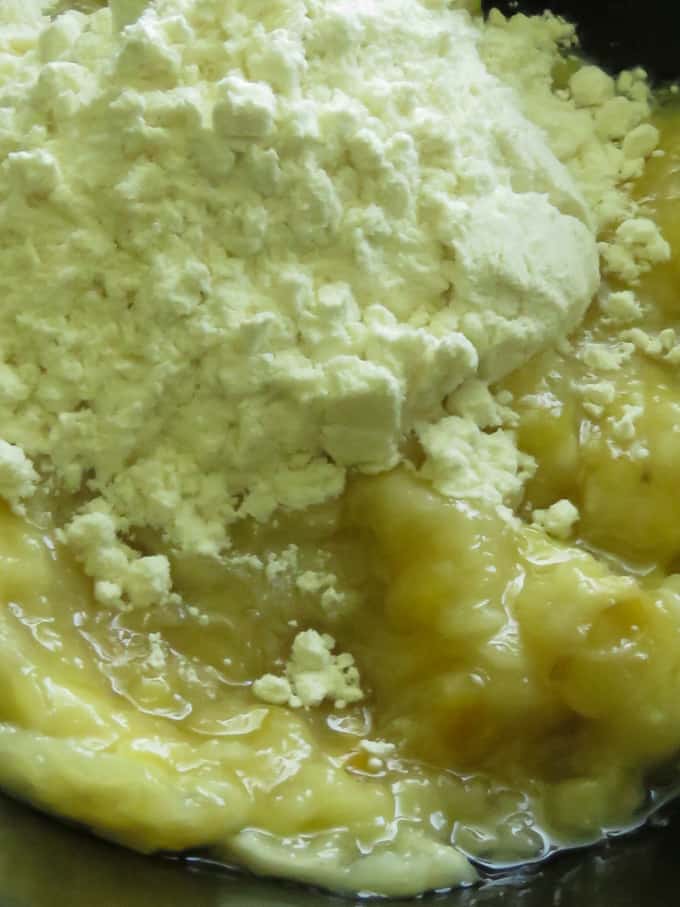 adding flour to the mashed banana to make the banana fritters(pisang goreng).