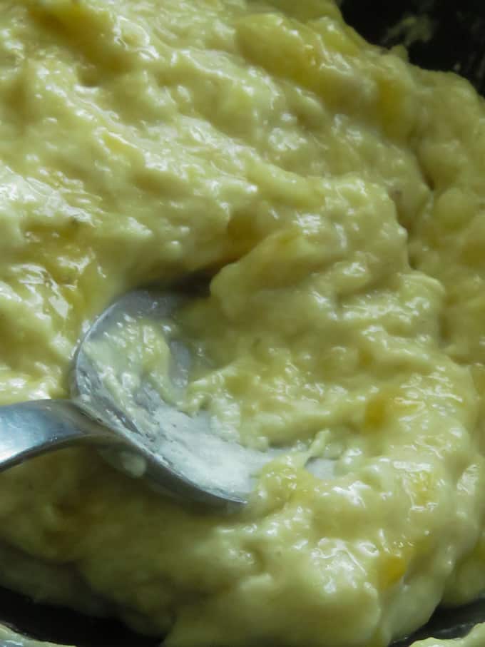 combining flour and the mashed banana to make pisang goreng.