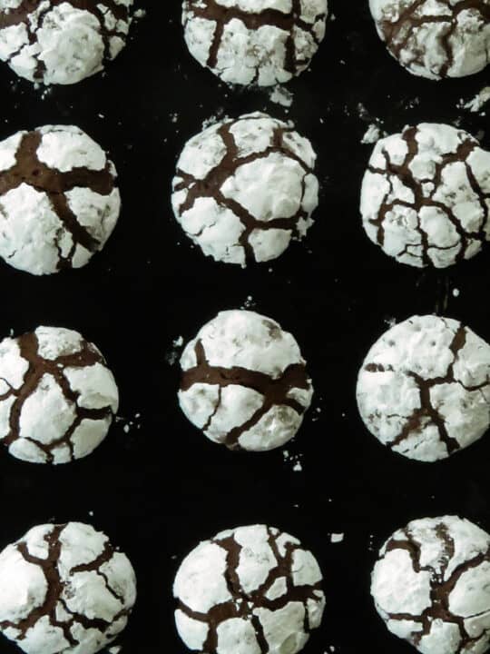 chocolate crinkle cookies all placed on a baking tray.