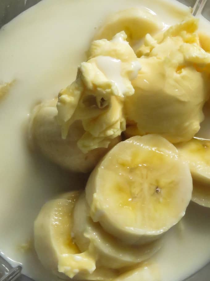 adding milk, butter into the blender full of banana.