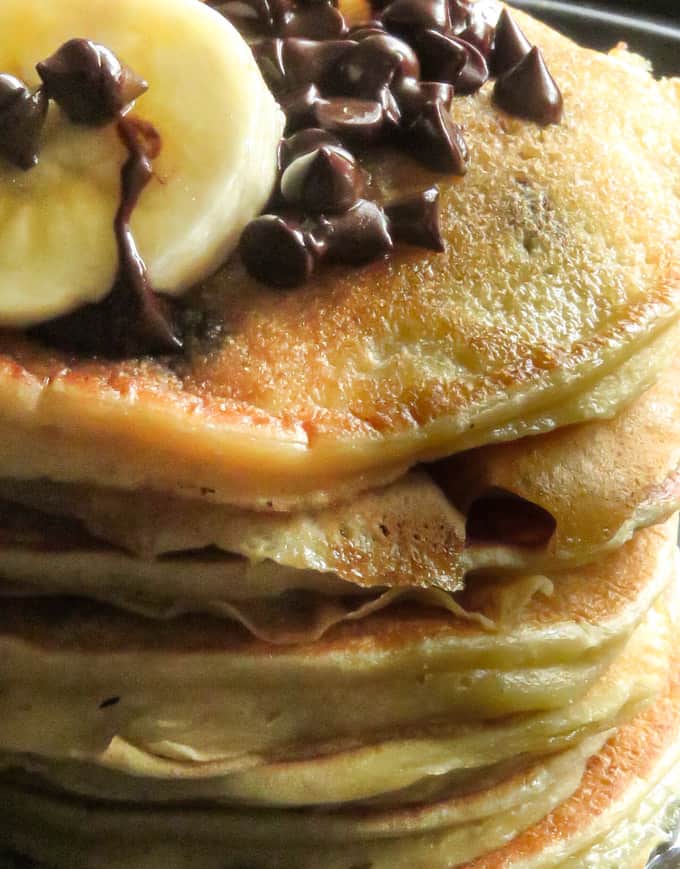 a stack of banana chocolate chip pancakes stacked with extra chocolate chips and slices of banana.