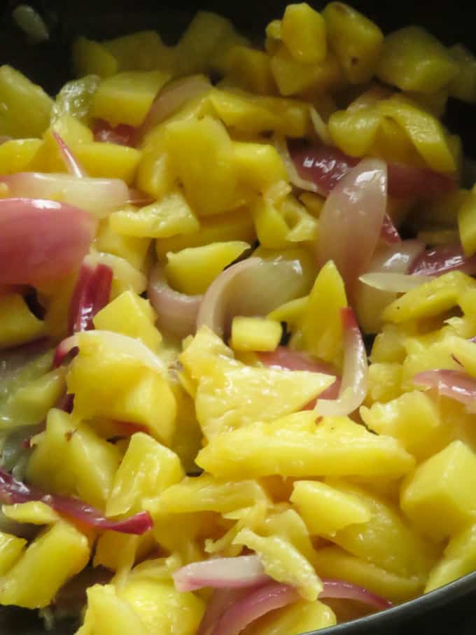 pineapple and onions cooking in a pan to add to the sweet and sour chicken recipe.