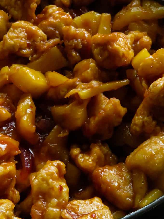 Adding the crispy chicken pieces to make the sweet and sour chicken.