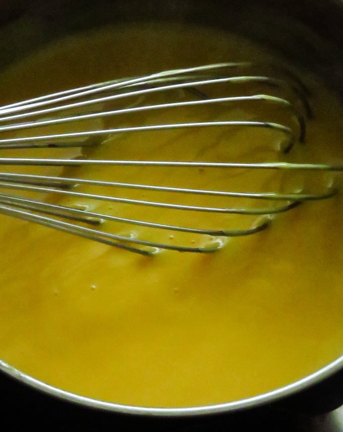 whisking the custard  mixture in warm heat to thicken