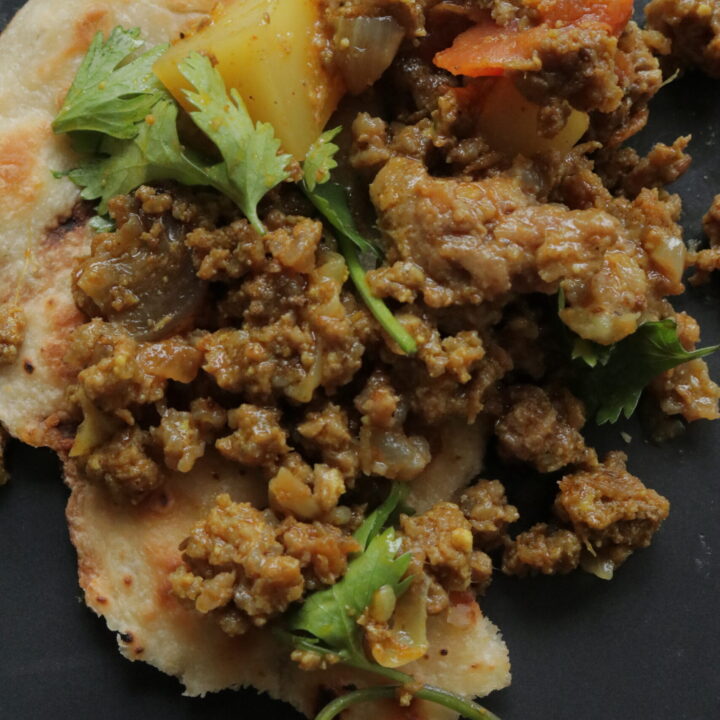 aloo keema on topped over a piece of naan roti,