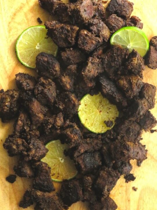 Sri Lankan beef fry with lime wedges.