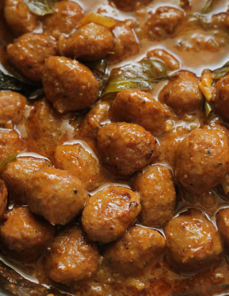 chicken meat ball curry in a spicy gravy and curry leaves.