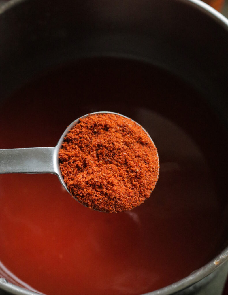 adding red chilli powder to make the spicy barbeque sauce