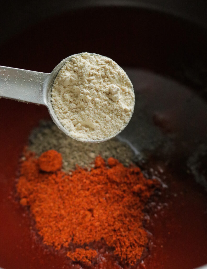 adding garlic powder to cook barbecue sauce