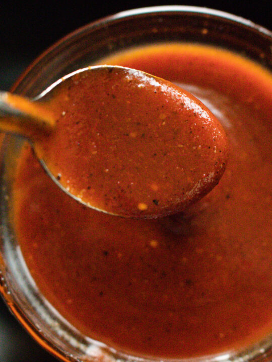 a babrbecue sauce bowl with a spoon in it