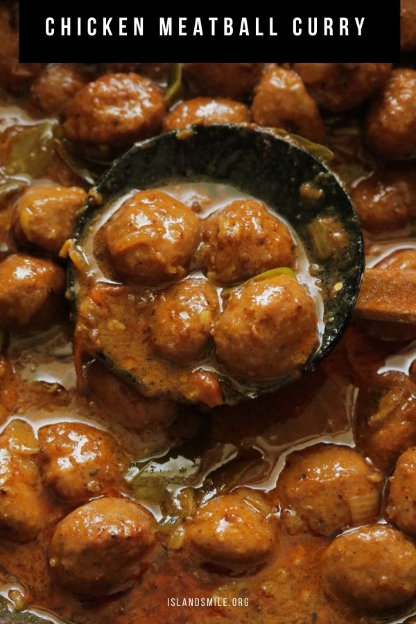 chicken meat ball scooped into a wooden spoon with coconut milk curry.