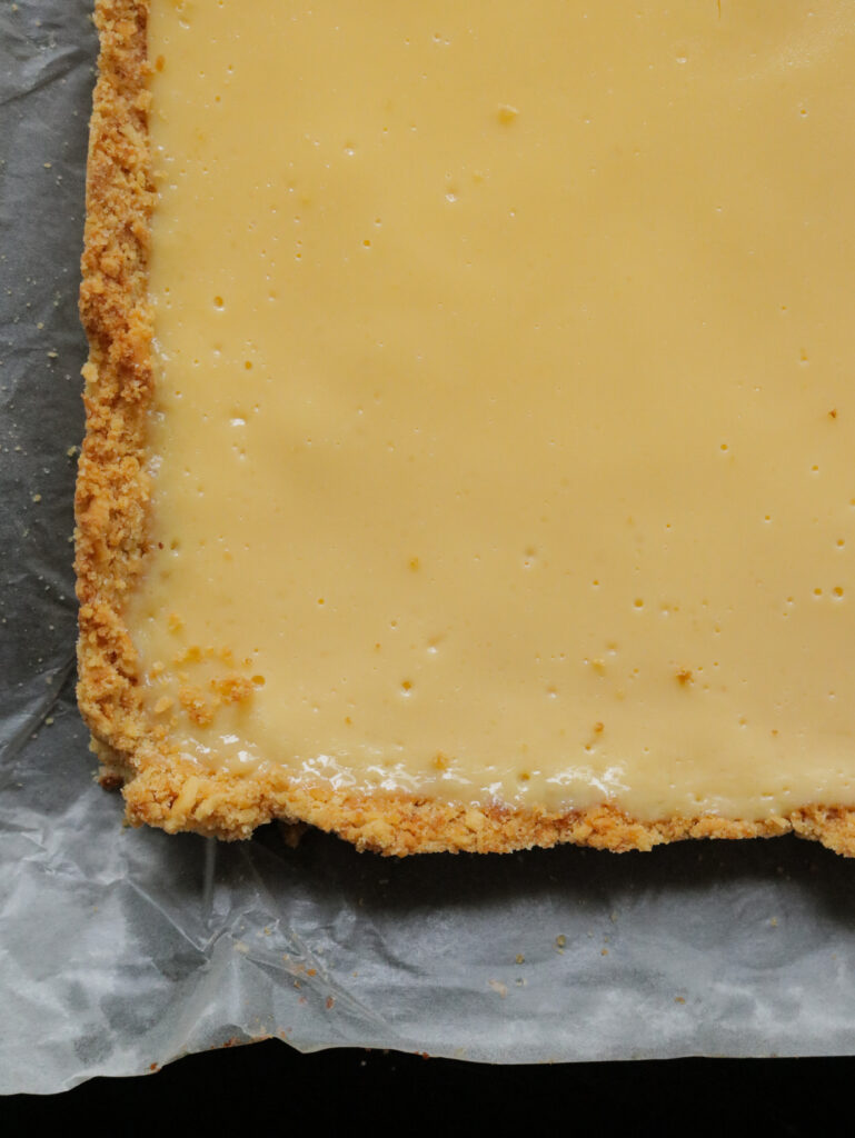 lemon bars with a biscuit crust placed on a baking paper.