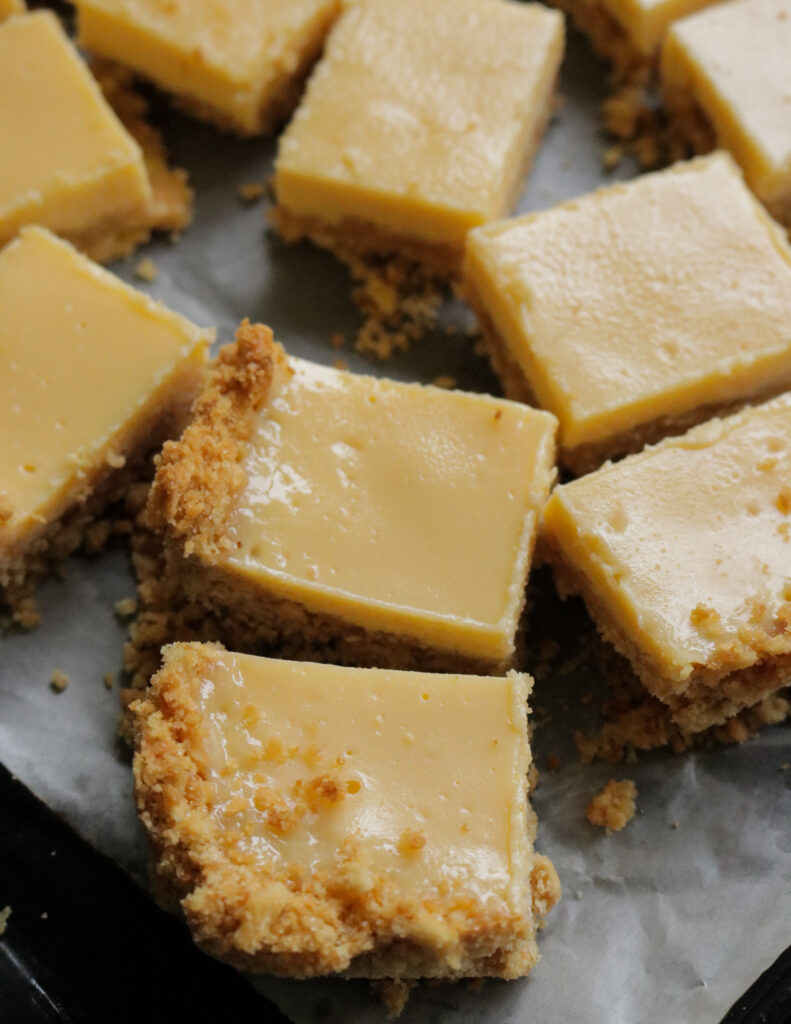 lemon bars with a crust placed on a baking paper.