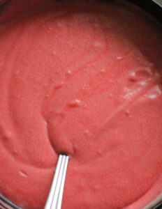 adding pink coloring to the cake