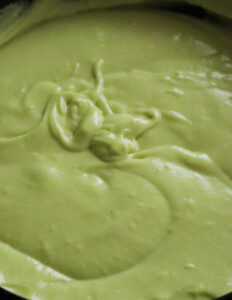 adding green coloring to the ribbon cake batter.