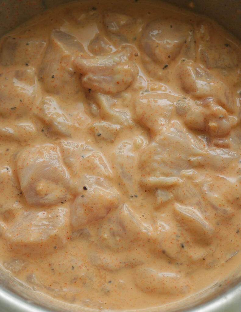 coating the chicken cubes in a batter.