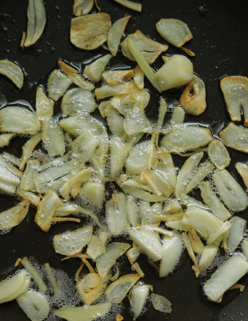 frying the garlic slices to make chillli chicken recipe.