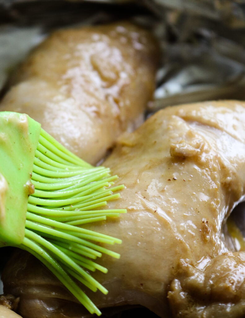 brushing the boiled chicken with garlic butter.