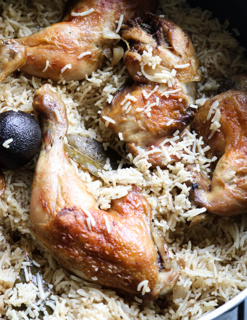 Arabic mandi rice with roaste chicken layered over the arabic rice.