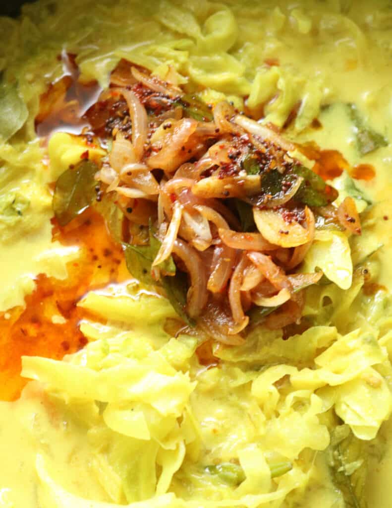 tempered onions, garlic, curry leaves in oil spread over the cooked cabbage curry.