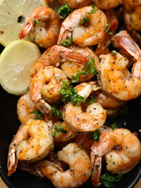 air fryer shrimp in a bowl with lime wedges