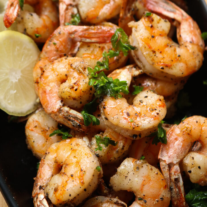 air fryer shrimp in a bowl with lime wedges