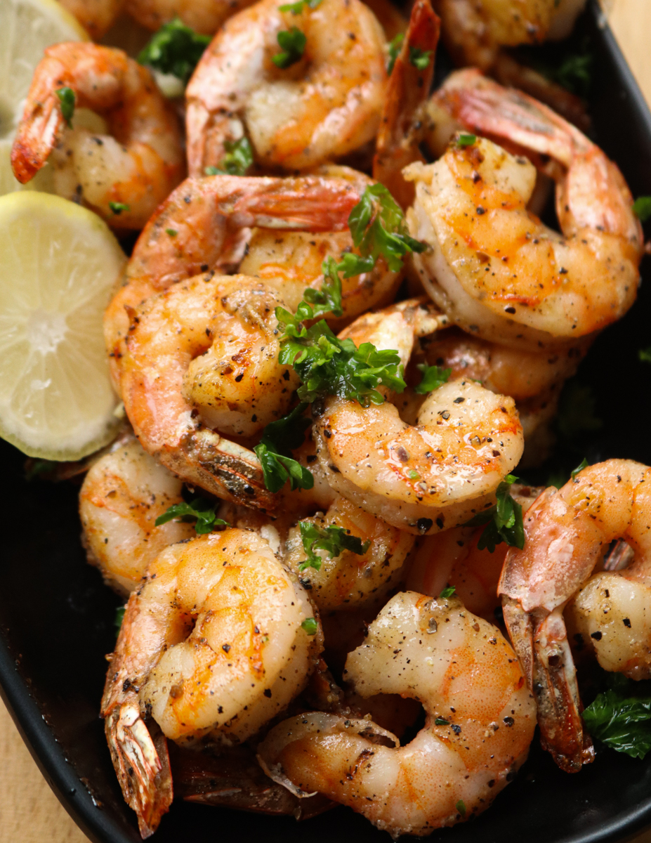 air fryer shrimp in a bowl with lime wedges