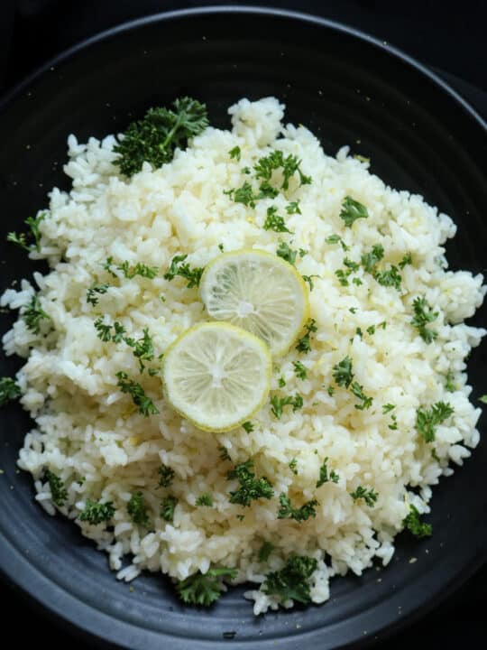 lemon rice recipe served in a platter with sliced lemons.