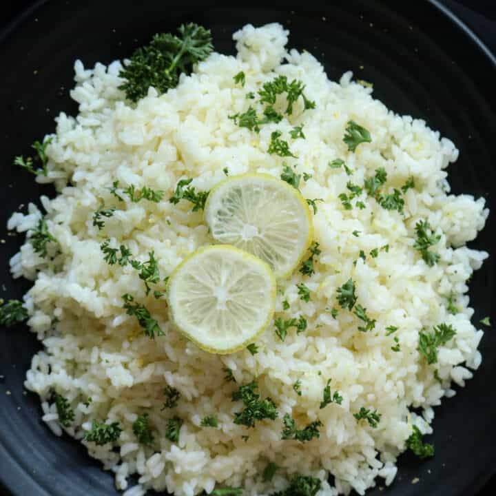 lemon rice recipe served in a platter with sliced lemons.