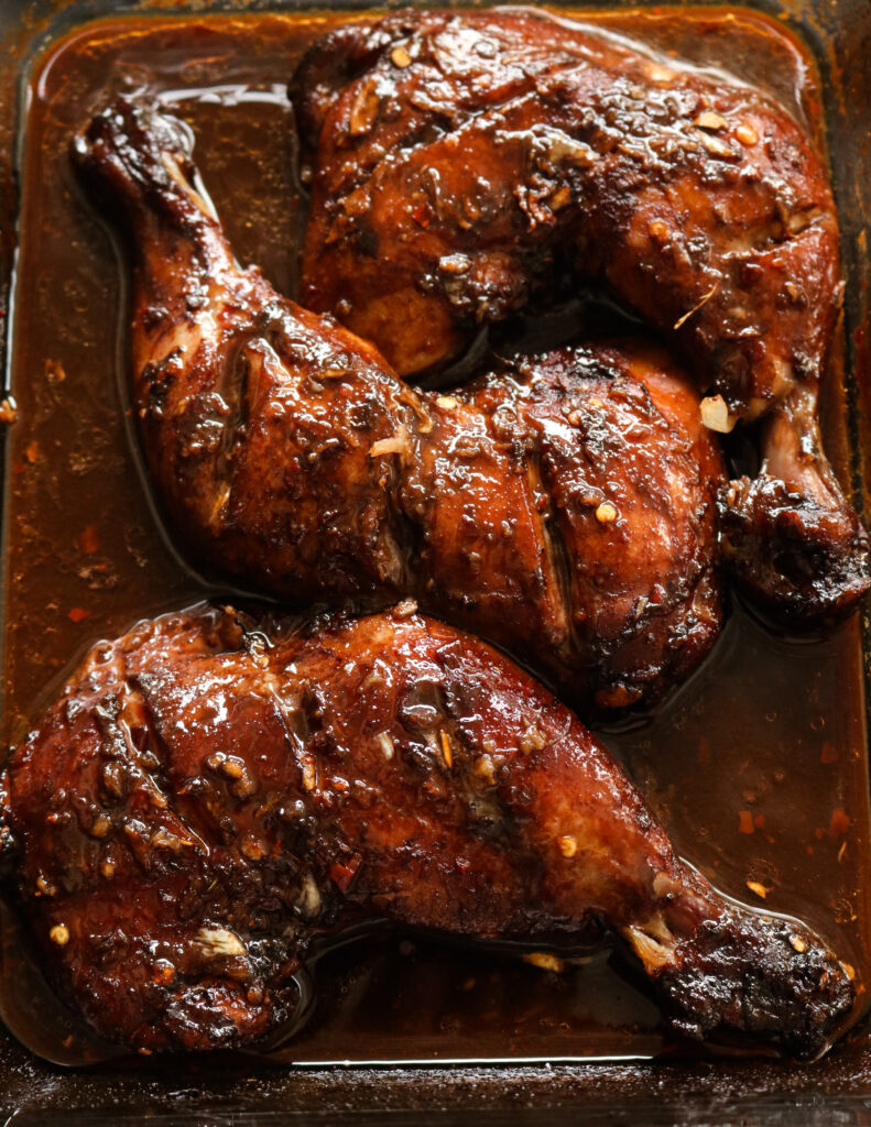 baked chicken quarters in teriyaki sauce ina pyrex dish with sauce