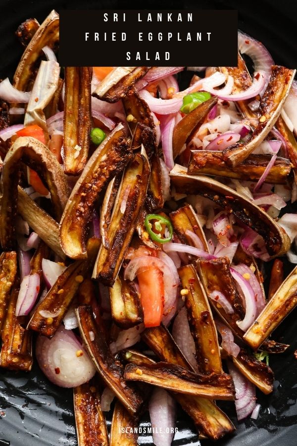 fried eggplants mixed in with onions and tomatoes served in a platter.